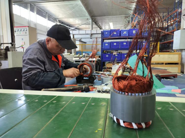 得普达电机车间工人正手工绕线生产电机定子。.jpg